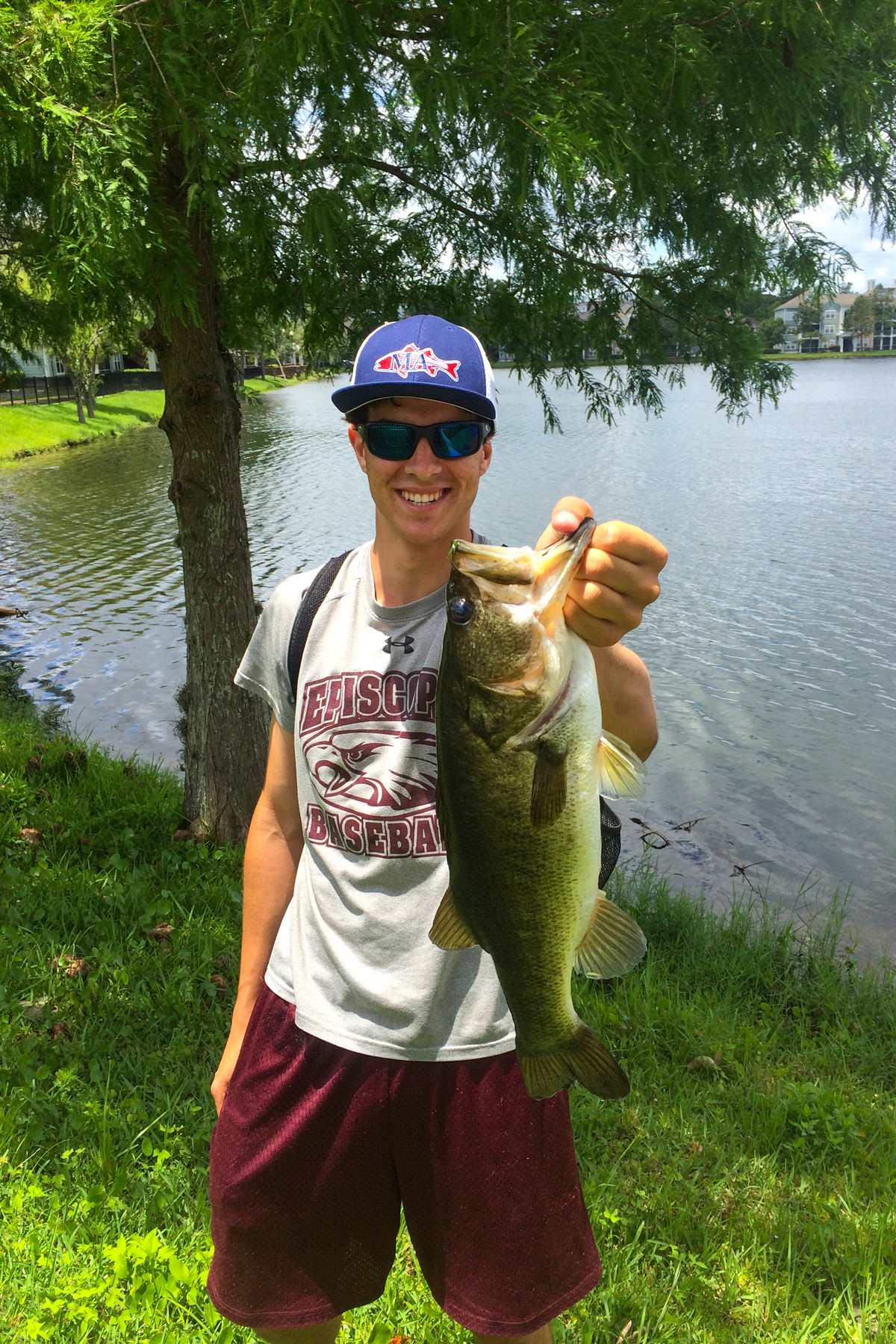 Holding a largemouth bass near a lake. 
